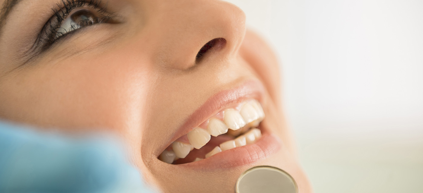 Mujer sonriendo en cita odontológica